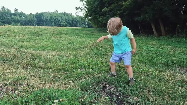 Cute laughing child dancing in nature. Merry dancing in the village. Hobby concepts, music, entertainment, development of motor coordination, good mood, parties, physical activity, melodies, pleasure