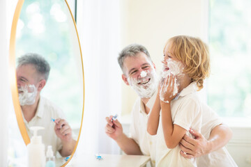 Father and child in bathroom looking in mirror