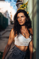 A beautiful brunette woman is walking on the city street of Alicante