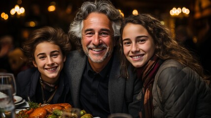 Fototapeta premium Close-up portrait of a family during a festive feast. Smiling people looking at the camera. Friendly family atmosphere, parents and children on holiday