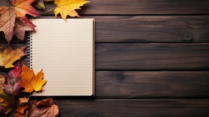 Notebook with autumn maple leaves on wooden background, top view, mockup, copy space, education concept