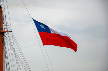 Flag of the Republic of Chile, waving with blue sky as background.
