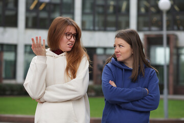 Young couple of lesbian women are arguing, quarreling outdoors. Problems in LGBT relationships.