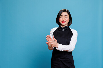 Cheerful asian waitress applauding and looking at camera with happy expression. Smiling joyful woman receptionist making applause, congratulating and celebrating success portrait