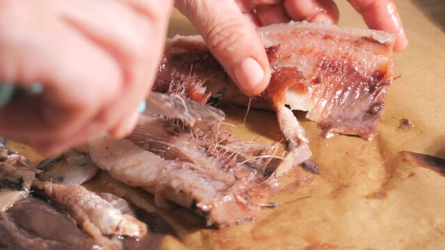 Female hands gutting herring in the home kitchen slow motion