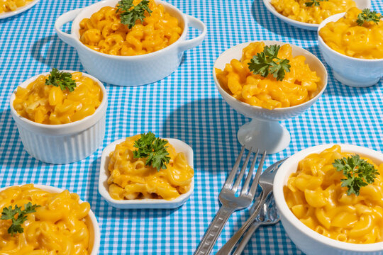 Macaroni and Cheese in various white dishes on blue gingham