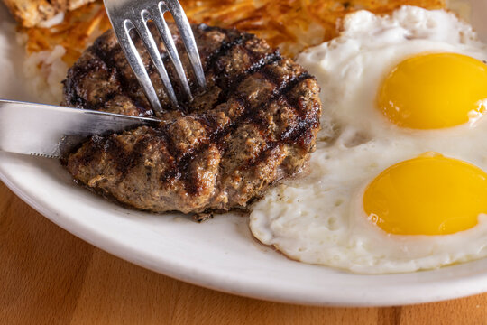 Cutting into meat, with eggs and hashbrowns