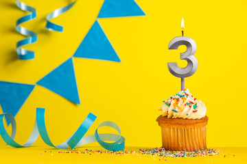 Lighted birthday candle number 3 - Yellow background with blue pennants