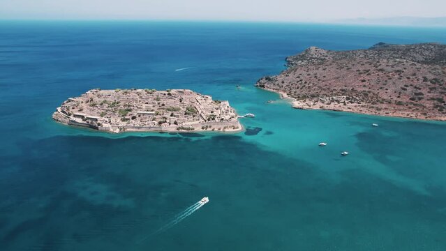 Spinalonga - island located in the Gulf of Elounda - seen from aerial perspective. Beautiful small islet surrounded by vivid blue seawater. High quality 4k footage