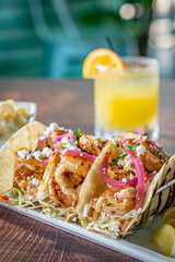 Blackened shrimp tacos with pickled red onion and mac and cheese.