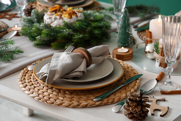 Festive table setting with plates, folded napkin and Christmas decorations