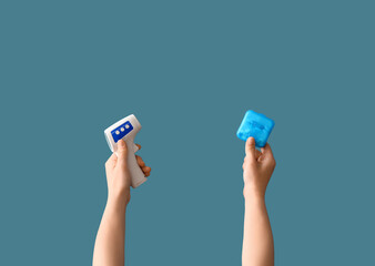 Doctor with infrared thermometer and pill box on blue background