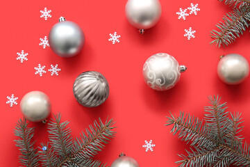 Christmas tree branches with balls and snowflakes on red background