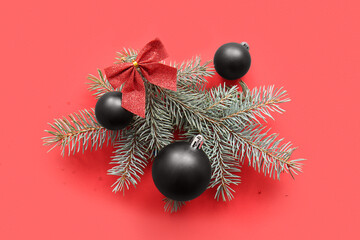 Christmas tree branches with balls and bow on red background