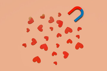 Magnet with paper hearts on beige background. Love concept