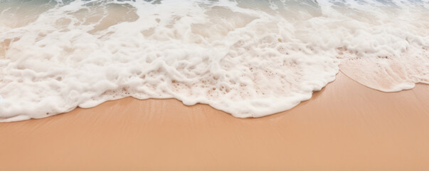 Texture of a frothy wave washing against a sandy beach, leaving behind a layer of foam that slowly dissipates into the sand, giving a soft and serene appearance.