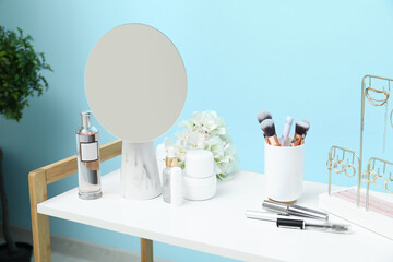 Different decorative cosmetics with mirror and jewellery on white table