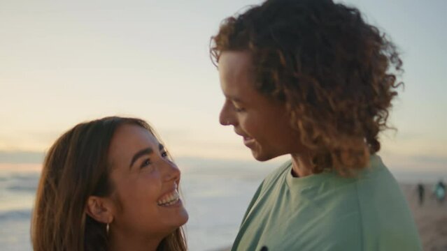 Love pair looking smartphone sunrise sea closeup. Young man kissing girlfriend