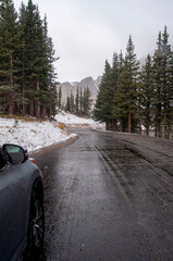 Car on a wet, snowy winter road in the rocky mountains of Colorado