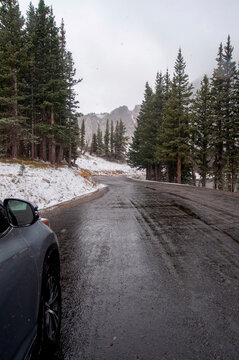 Car on a wet, snowy winter road in the rocky mountains of Colorado
