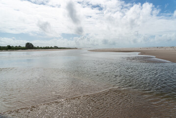 Waters from a river that flows into the sea. white sand on the beach. Preserved environment.