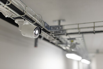Security camera mounted on a metal structure near the ceiling in the server room. 