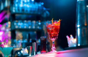 Professional male bartender preparing and serving cocktail drink to customer on bar counter at luxury nightclub. Barman making mixed alcoholic drink for celebrating holiday party at restaurant bar.