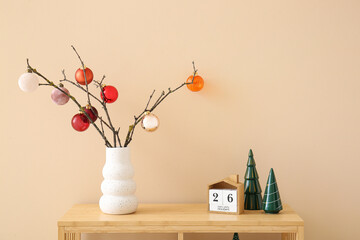 Wooden shelving unit with Christmas decor near beige wall
