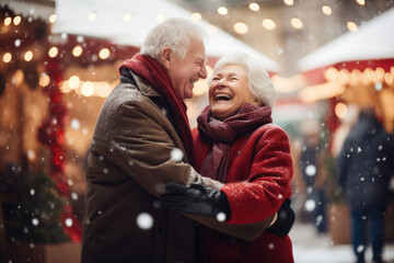 Beautiful senior couple dancing together on traditional Christmas market on winter evening. Elderly woman and man enjoying themselves in Christmas town decorated with lights. - obrazy, fototapety, plakaty