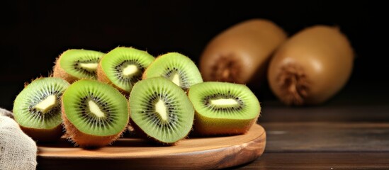 Sliced kiwi on old wooden table With copyspace for text - obrazy, fototapety, plakaty