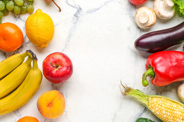 Frame made of fresh vegetables and fruits on white marble background. World Vegan Day concept