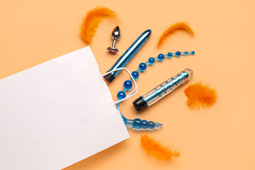 White shopping bag with sex toys and feathers on beige background