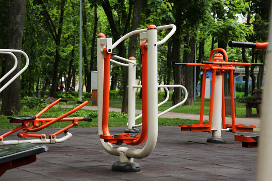 Empty outdoor gym with air walker, push up bars, rowing machine and double abductor