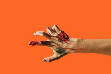 Zombie hand on orange background. Halloween celebration