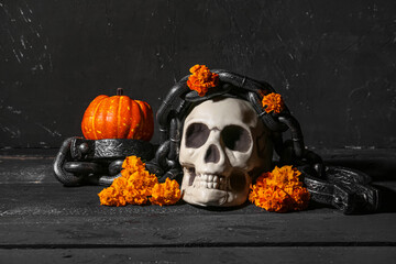 Halloween composition with skull, pumpkin and shackles on black grunge background