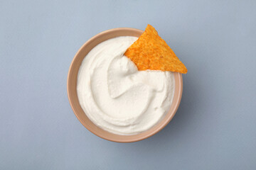Delicious tofu sauce served with nachos chip in bowl on grey background, top view