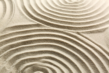 Fototapeta na wymiar Beautiful patterns on sand, closeup. Zen garden
