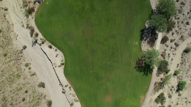 Aerial of golf course nestled amongst dramatic desert mountains in La Quinta
