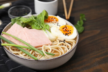 Delicious ramen with meat on wooden table, closeup with space for text. Noodle soup