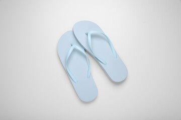 Light blue flip flops on white background, top view