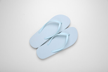 Light blue flip flops on white background, top view