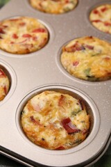 Freshly baked bacon and egg muffins with cheese in tin, closeup