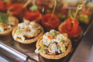 Catering table, beautifully decorated banquet with variety of with different food snacks appetizers on corporate birthday party event or wedding celebration, canape, salad, delicatessen setting