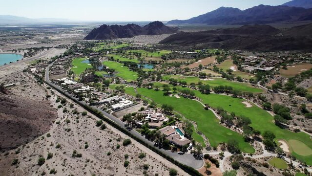 Aerial of golf course nestled amongst dramatic desert mountains in La Quinta