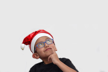 6 year old dark latino boy with eye glasses is ready to celebrate the holidays and write his letter...