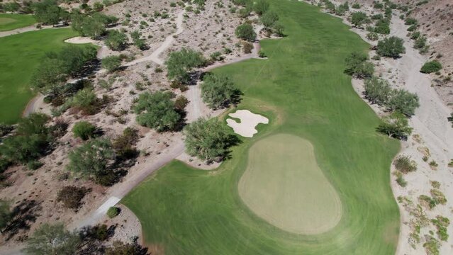 Aerial of golf course nestled amongst dramatic desert mountains in La Quinta