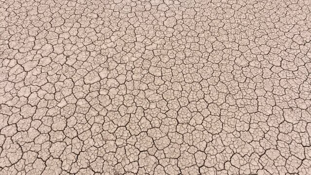 Aerial shot looking down at the cracked surface of a dry lake in Navada
