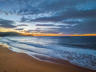 Surf, sea, sand, sunrise with clouds