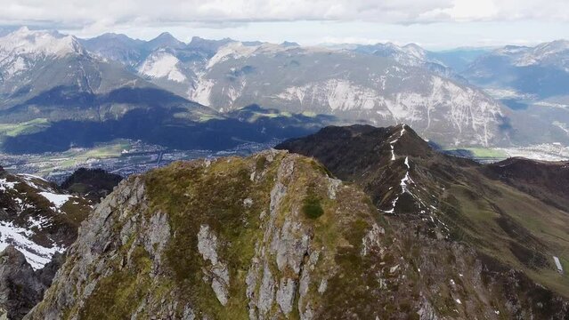 Cinematic aerial of alps mountain top with old wooden chapel on steep peak. Beautiful alpine scenery with valley in distance landscape view. Kellerjoch, Austria. Drone flying around summit, orbit shot