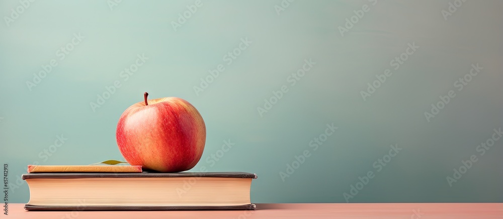Poster copy space image on isolated background with an apple on top of books